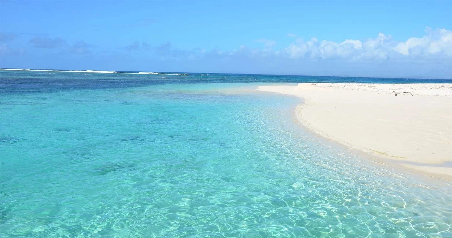 Plage de sable blanc et eau turquoise de l'Île Plate